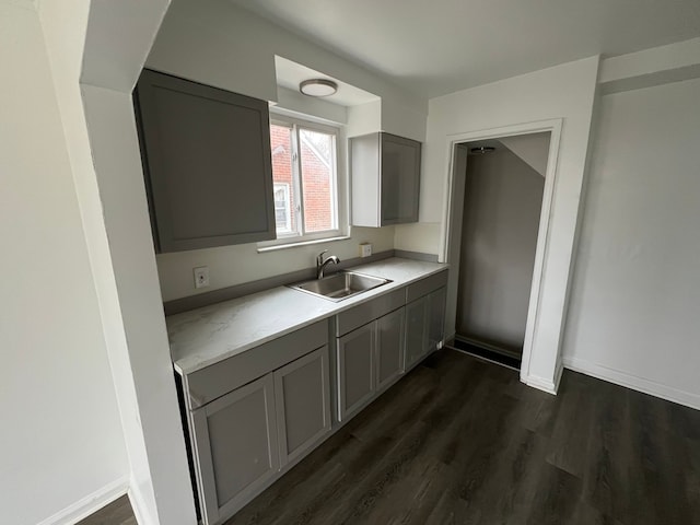 kitchen with gray cabinetry, sink, and dark hardwood / wood-style flooring