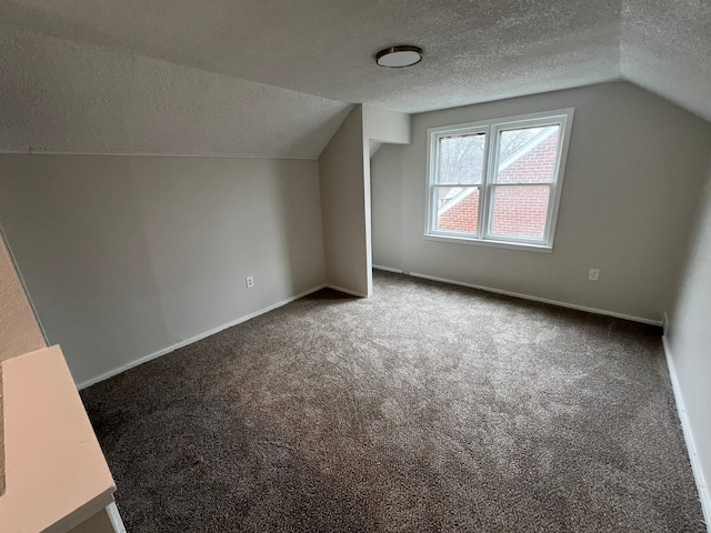 bonus room featuring a textured ceiling, carpet floors, and vaulted ceiling