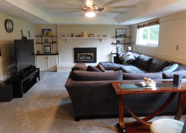 carpeted living room with a fireplace, a textured ceiling, and ceiling fan