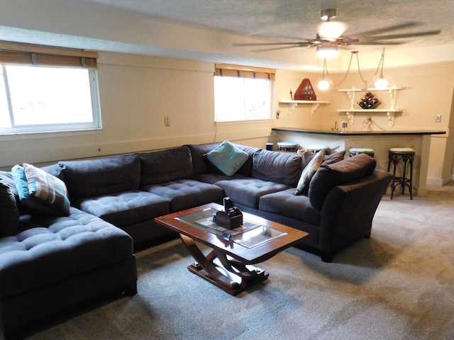 living room with carpet flooring, a textured ceiling, and ceiling fan