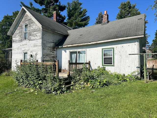 back of property featuring a lawn and a deck