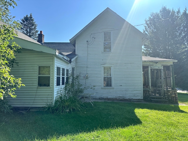 back of house with a sunroom and a yard