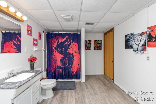 full bathroom featuring wood finished floors, visible vents, vanity, and a drop ceiling
