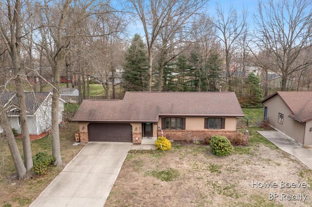 ranch-style home with brick siding, driveway, a shingled roof, and a garage
