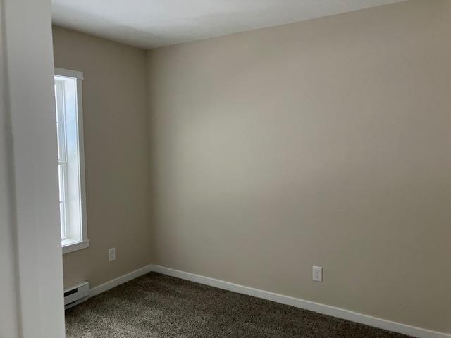 2711 Sawyer Rd, Traverse City, MI 49685 - carpeted empty room with a baseboard radiator