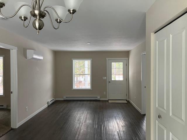 2711 Sawyer Rd, Traverse City, MI 49685 - entryway featuring a wall mounted AC, dark hardwood / wood-style flooring, a chandelier, and a baseboard heating unit