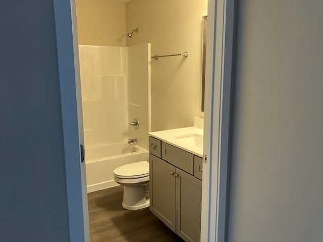 2711 Sawyer Rd, Traverse City, MI 49685 - full bathroom with shower / bath combination, vanity, wood-type flooring, and toilet