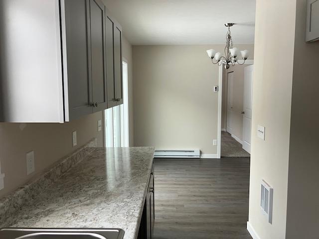 2711 Sawyer Rd, Traverse City, MI 49685 - kitchen with gray cabinetry, a chandelier, dark hardwood / wood-style floors, and a baseboard heating unit