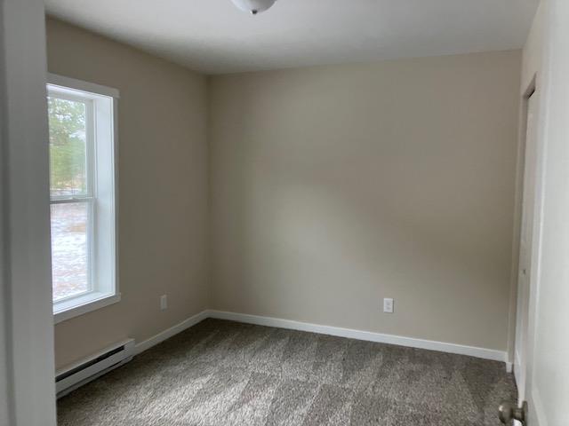 2711 Sawyer Rd, Traverse City, MI 49685 - empty room featuring carpet floors and a baseboard heating unit