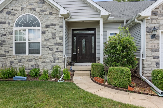 view of exterior entry featuring a yard