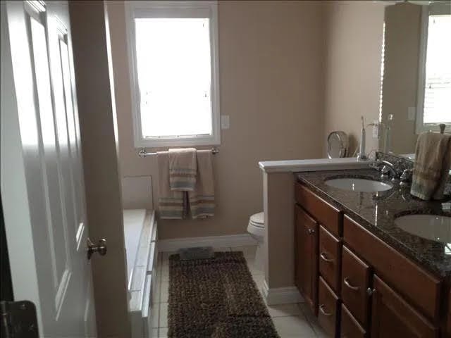 bathroom featuring tile patterned flooring, vanity, toilet, and a healthy amount of sunlight