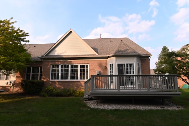 rear view of house with a yard and a wooden deck