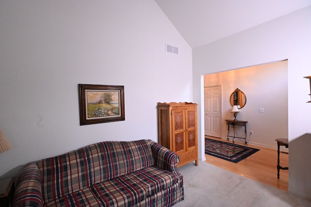 living room featuring wood-type flooring and high vaulted ceiling