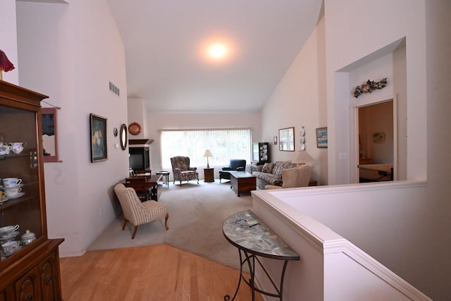 living room with light carpet and high vaulted ceiling