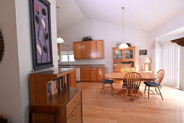 dining area with light hardwood / wood-style floors and vaulted ceiling