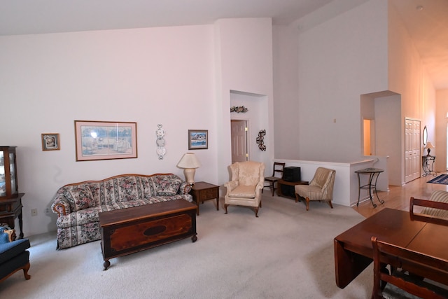 carpeted living room with high vaulted ceiling