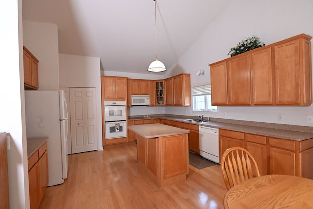 kitchen with white appliances, high vaulted ceiling, sink, light hardwood / wood-style flooring, and a kitchen island