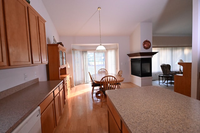 kitchen featuring pendant lighting, dishwasher, a multi sided fireplace, and light hardwood / wood-style flooring