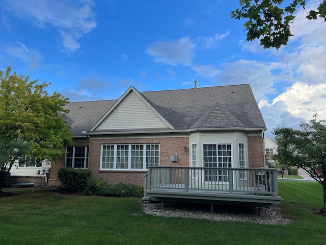 back of house with a deck and a lawn