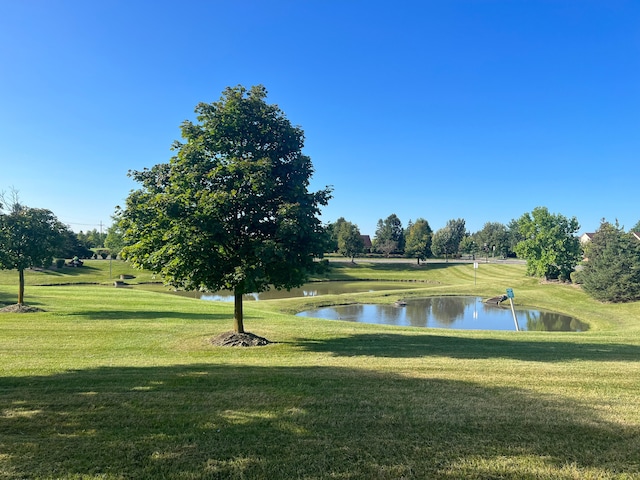 surrounding community featuring a lawn and a water view