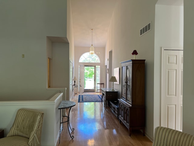 entryway featuring a chandelier, a high ceiling, and hardwood / wood-style flooring