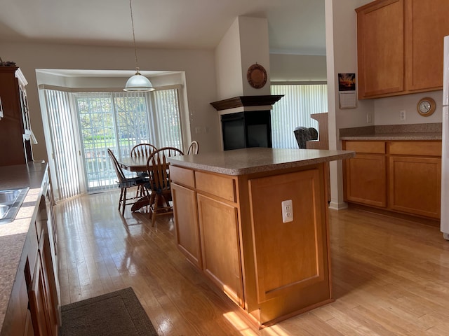 kitchen with pendant lighting, a kitchen island, and light wood-type flooring