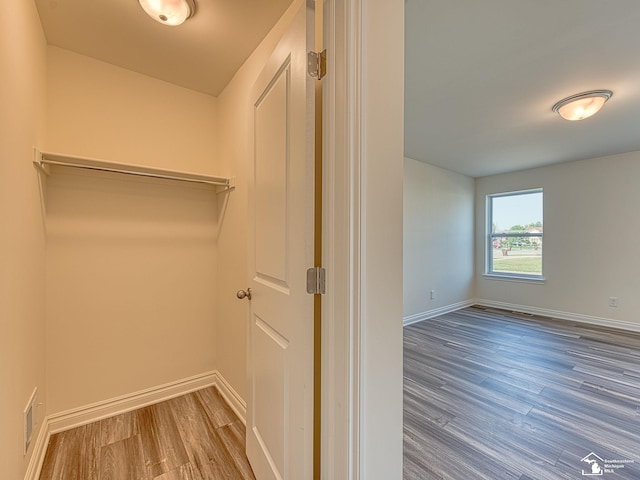 walk in closet with hardwood / wood-style floors