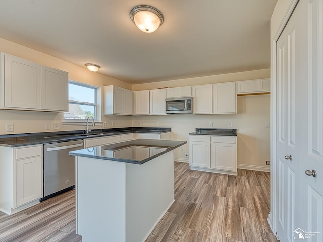 kitchen featuring white cabinetry, a center island, sink, and appliances with stainless steel finishes