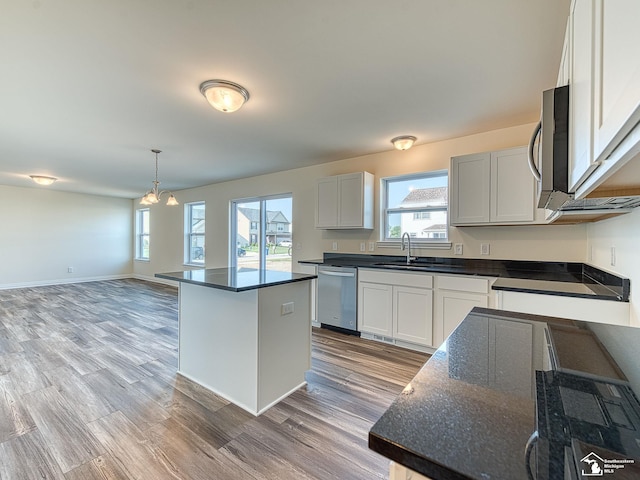 kitchen featuring appliances with stainless steel finishes, a center island, light hardwood / wood-style flooring, and plenty of natural light