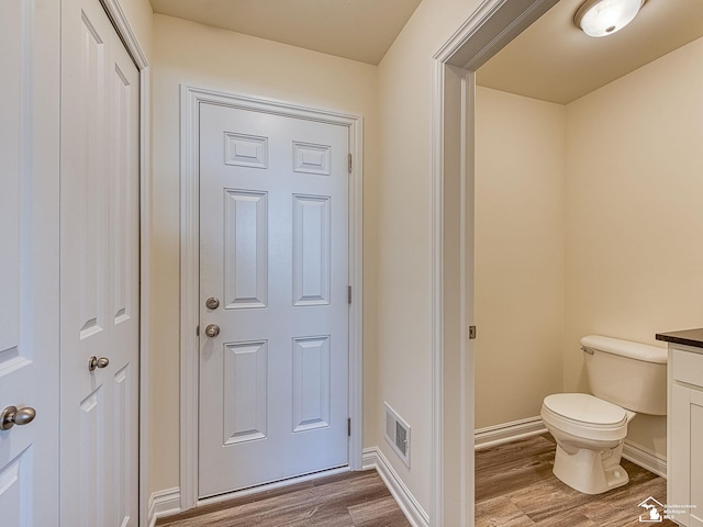 bathroom with hardwood / wood-style flooring, vanity, and toilet