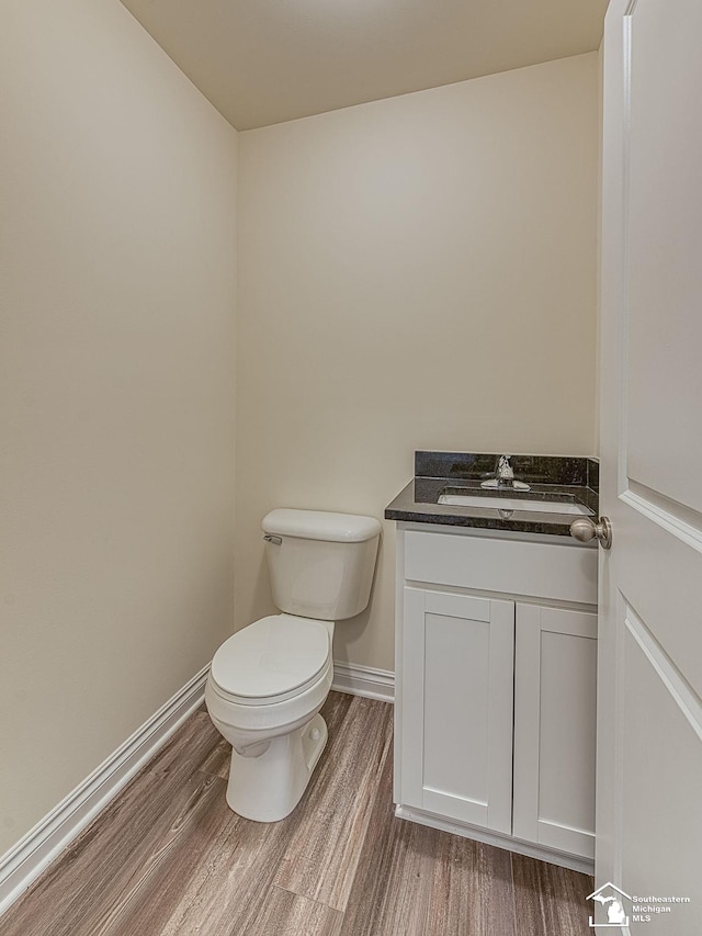 bathroom featuring hardwood / wood-style floors, vanity, and toilet