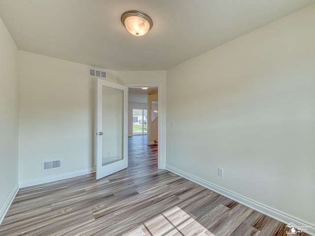 empty room featuring light hardwood / wood-style flooring and french doors