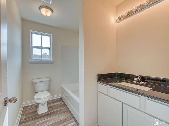 bathroom with wood-type flooring, vanity, and toilet