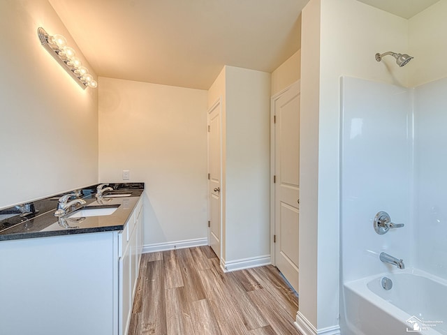 bathroom featuring hardwood / wood-style floors, vanity, and shower / washtub combination