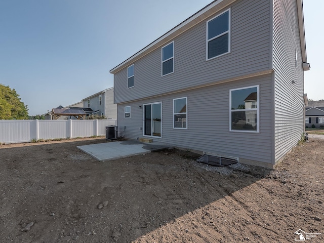 rear view of house with central AC unit and a patio area