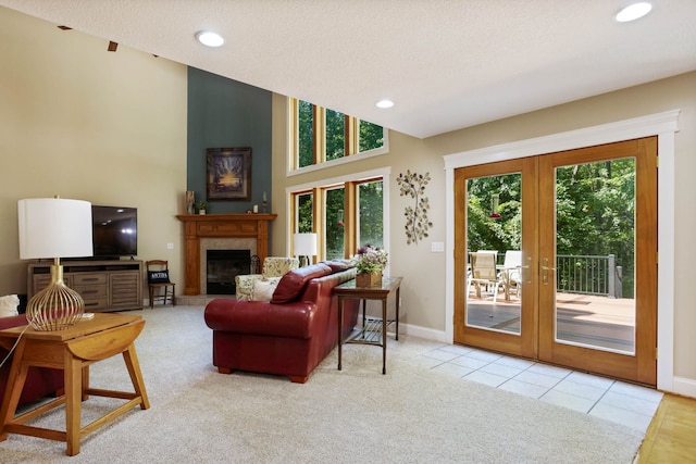 carpeted living room with a glass covered fireplace, french doors, a textured ceiling, and recessed lighting