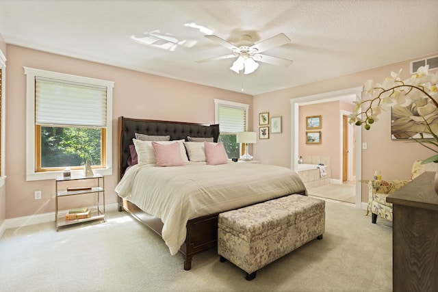 carpeted bedroom featuring baseboards, visible vents, a ceiling fan, and ensuite bathroom