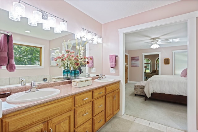 ensuite bathroom featuring double vanity, tile patterned flooring, a sink, and ensuite bathroom