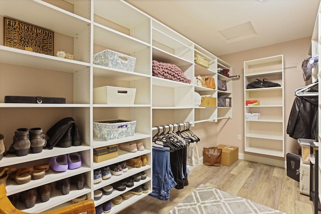 spacious closet with attic access and wood finished floors