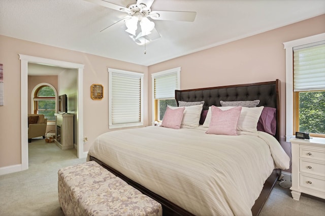 bedroom featuring light carpet, ceiling fan, and baseboards