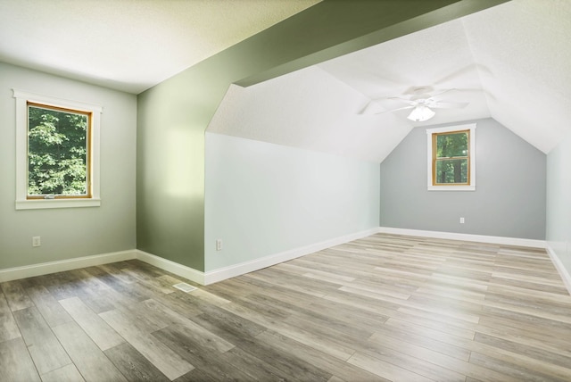 bonus room with baseboards, plenty of natural light, and light wood finished floors