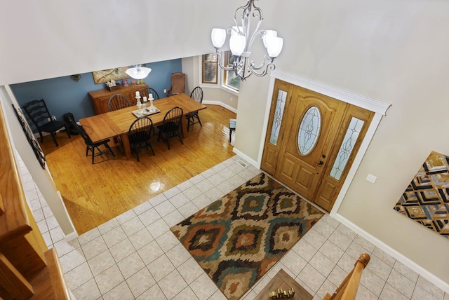 entrance foyer featuring light tile patterned floors, baseboards, and a notable chandelier