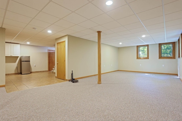 basement featuring recessed lighting, light colored carpet, freestanding refrigerator, a drop ceiling, and baseboards