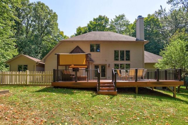 back of property featuring a deck, a yard, and fence