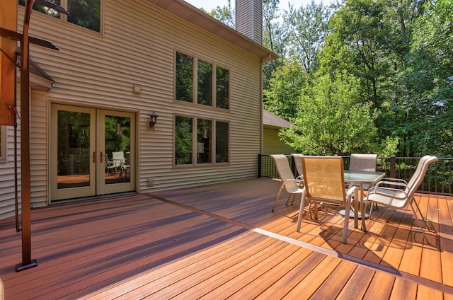 wooden terrace featuring outdoor dining space and french doors