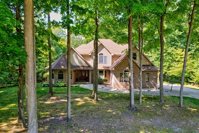 view of front of home with brick siding and a shingled roof