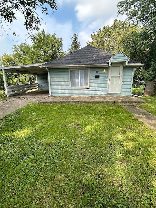 single story home featuring a front lawn and a carport