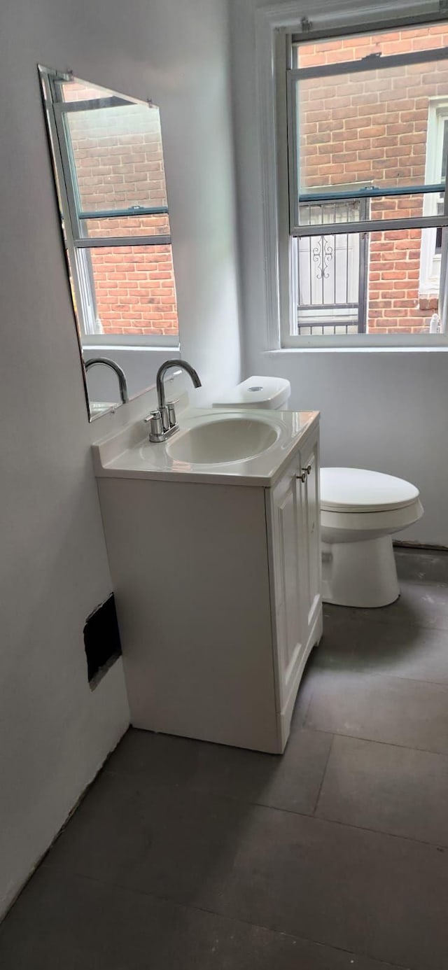 bathroom with tile patterned flooring, vanity, and toilet