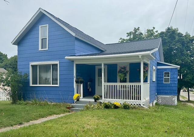 bungalow with covered porch and a front lawn