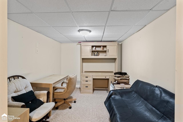 carpeted office space with a drop ceiling